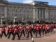 red coated guards leaving buckingham palace